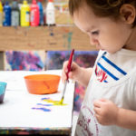 Un enfant concentré sur sa peinture en atelier KID & Sens à Aix en Provence
