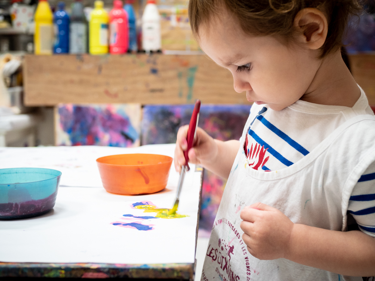 Un enfant concentré sur sa peinture en atelier KID & Sens à Aix en Provence